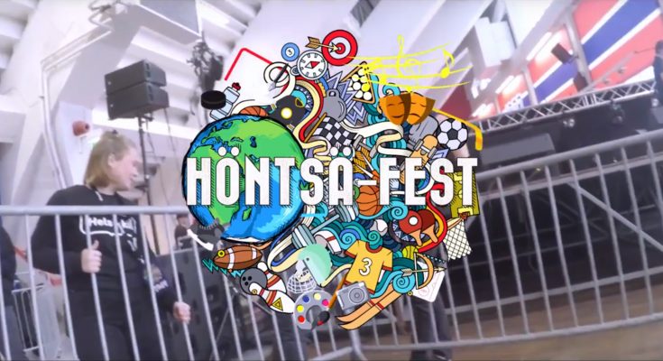 Kuvakaappaus Stadin ammattiopiston Höntsä-Fest-videosta, jossa näkyy tapahtuman logo ja taustalla nuoria asettelamassa keikan aitoja paikoilleen.